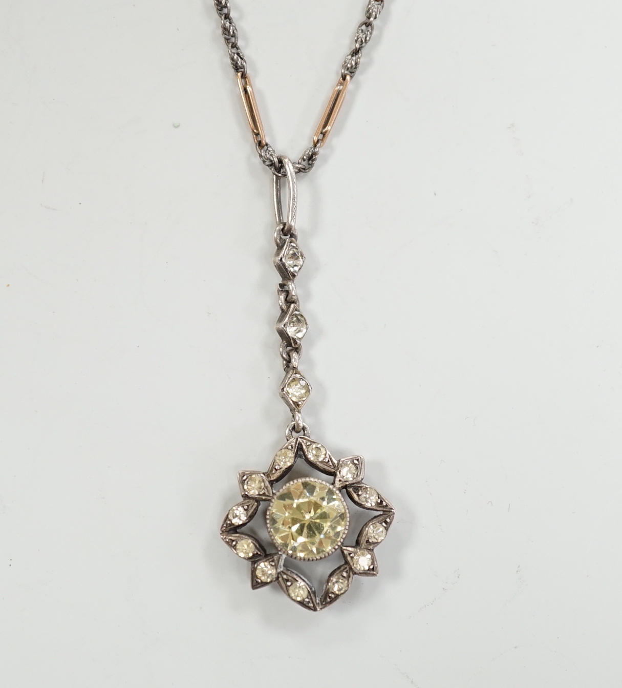 A 19th century white metal and foil backed paste set pendant, 40mm, on a later two colour chain, the clasp stamped 9ct.